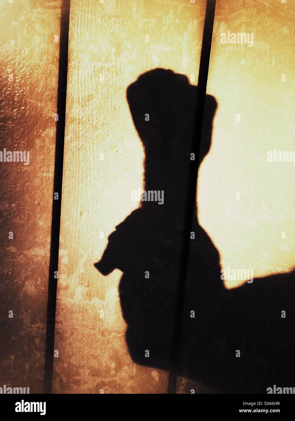 Un hombre arroja sombras sobre una pared, contando en su mano. Número Cero. Foto de stock