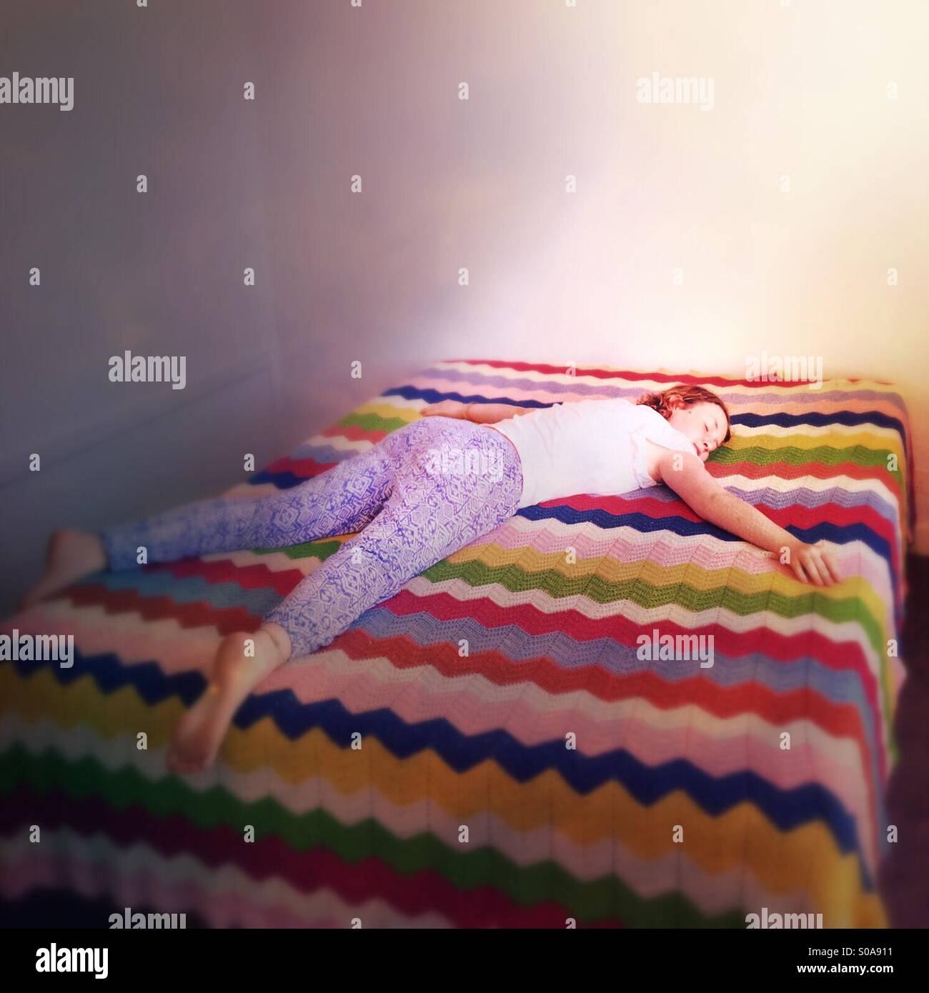 Chica durmiendo en cama con coloridos manta casera Fotografía de stock -  Alamy
