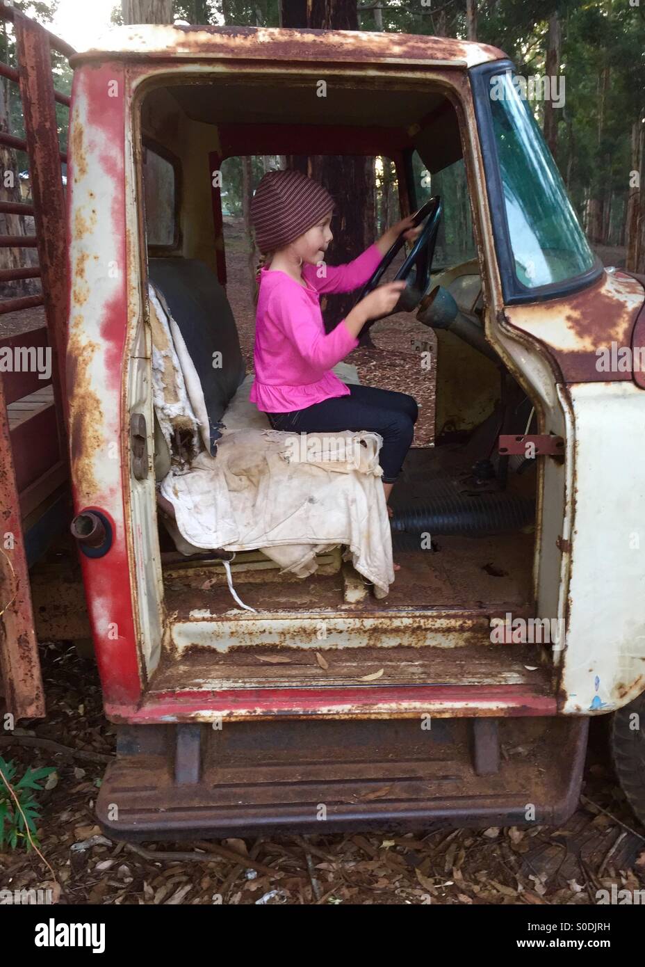 Niño fingiendo duro viejo camión abandonada Foto de stock
