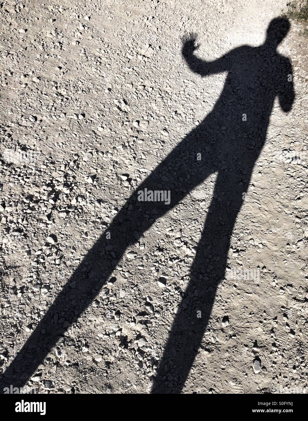 La sombra de un hombre real con largas piernas, agitando. Foto de stock