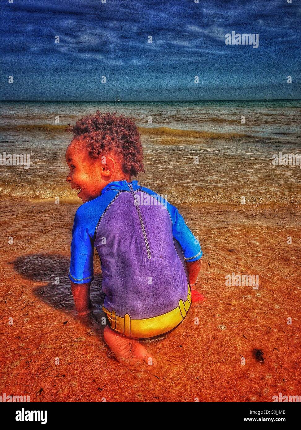 El muchacho en la playa. Foto de stock
