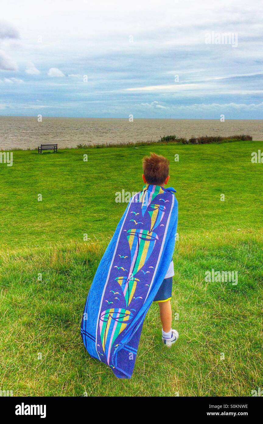 Pequeño niño finge ser super héroe con una toalla de playa antes de un  viaje a una playa inglesa ventosos Fotografía de stock - Alamy