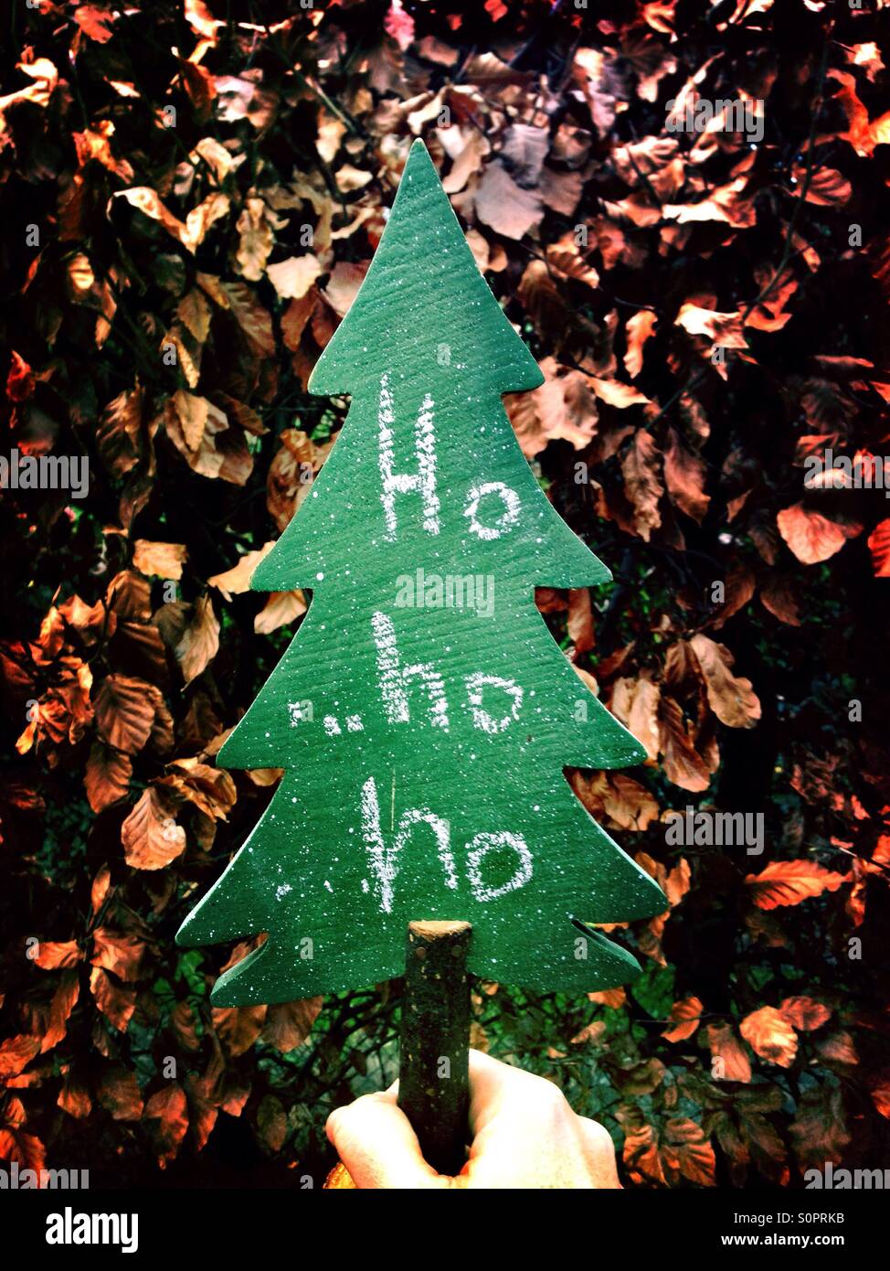 Mensaje de Navidad Ho Ho Ho en un artesonado de madera de árbol de navidad Foto de stock