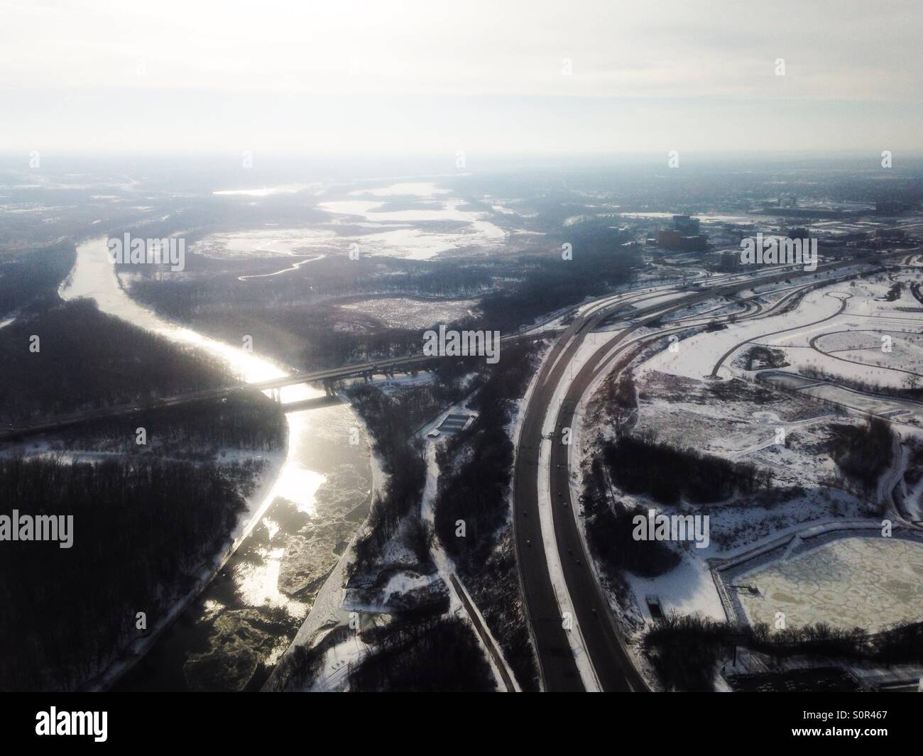 Una vista aérea de una carretera junto a un río cerca de Minneapolis, Minnesota, en invierno. Foto de stock