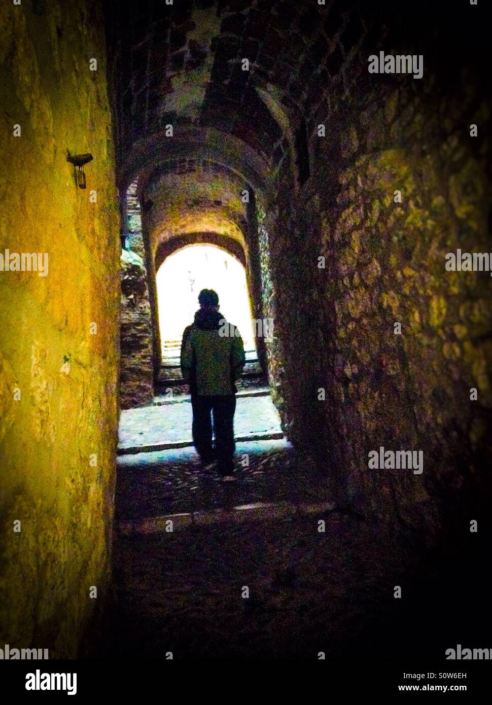 Solo silueta caminando por un oscuro callejón en el Call (barrio judío), Girona, Cataluña Foto de stock