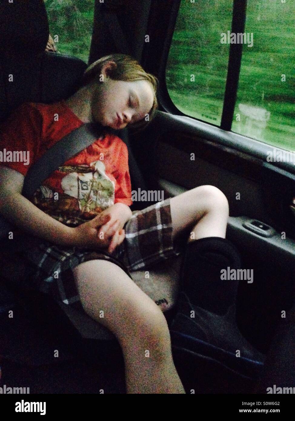 Niño durmiendo en el coche durante el viaje por carretera Foto de stock