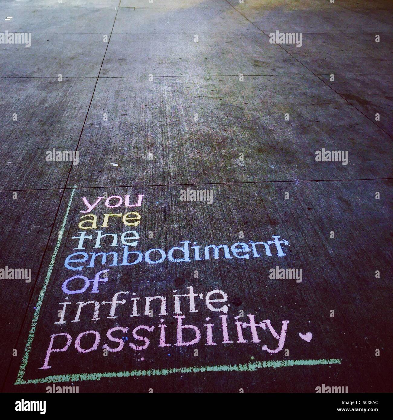 Tú eres la personificación de infinitas posibilidades cita inspiradora sobre pavimento en NYC Foto de stock
