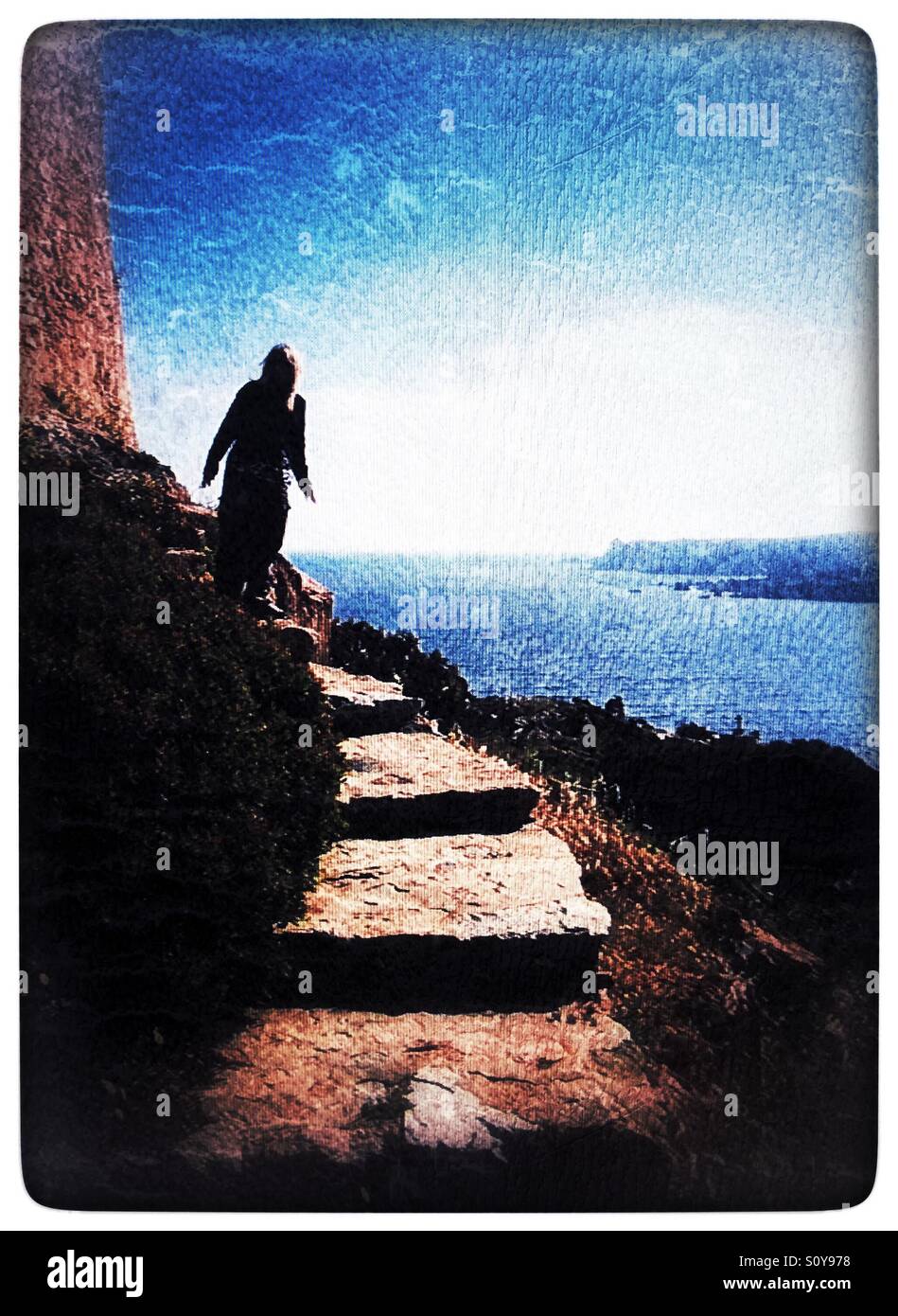 Mujer en escalones de piedra en los océanos edge Foto de stock