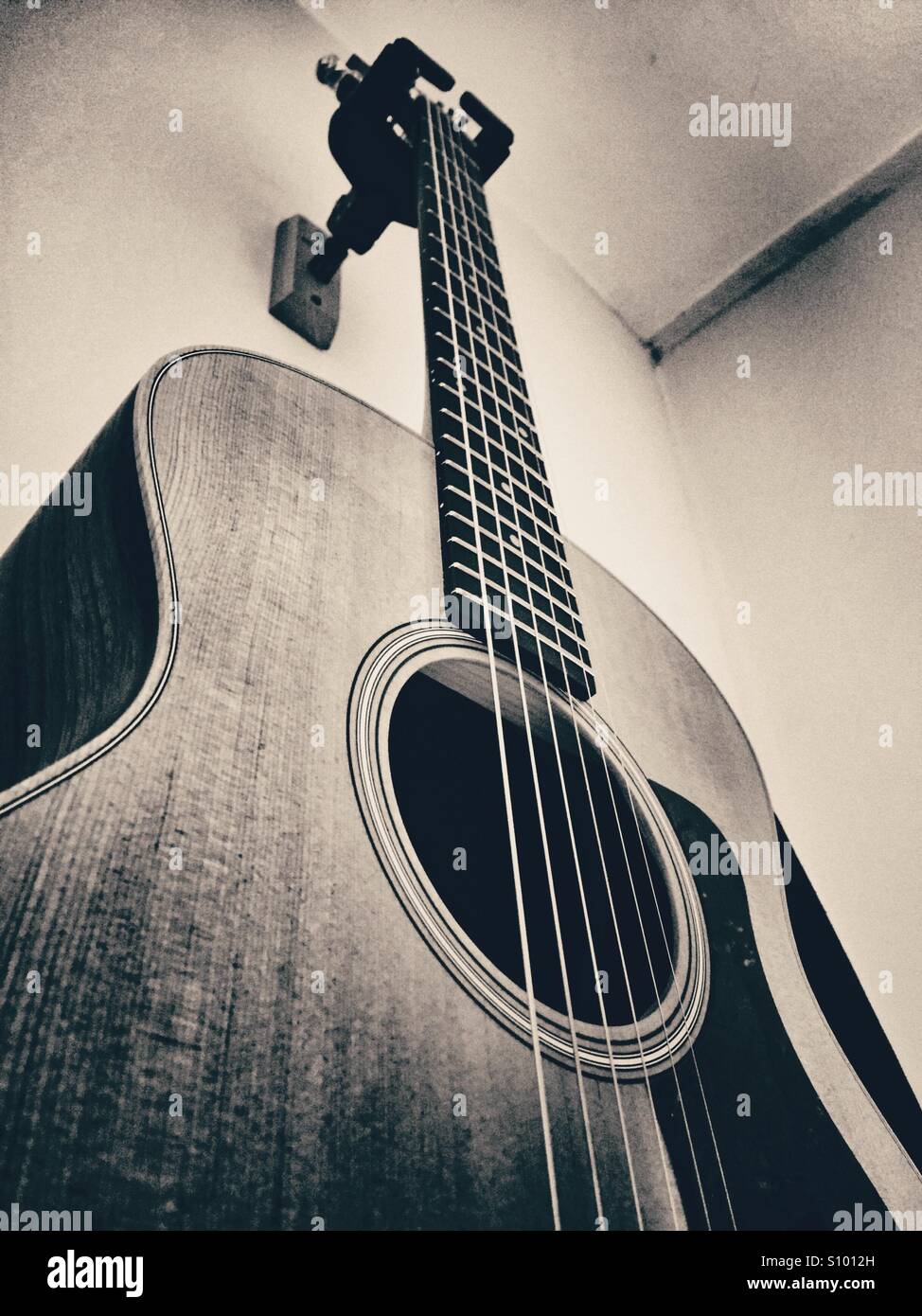 Guitarra acústica colgada en la pared en blanco y negro Fotografía de stock  - Alamy