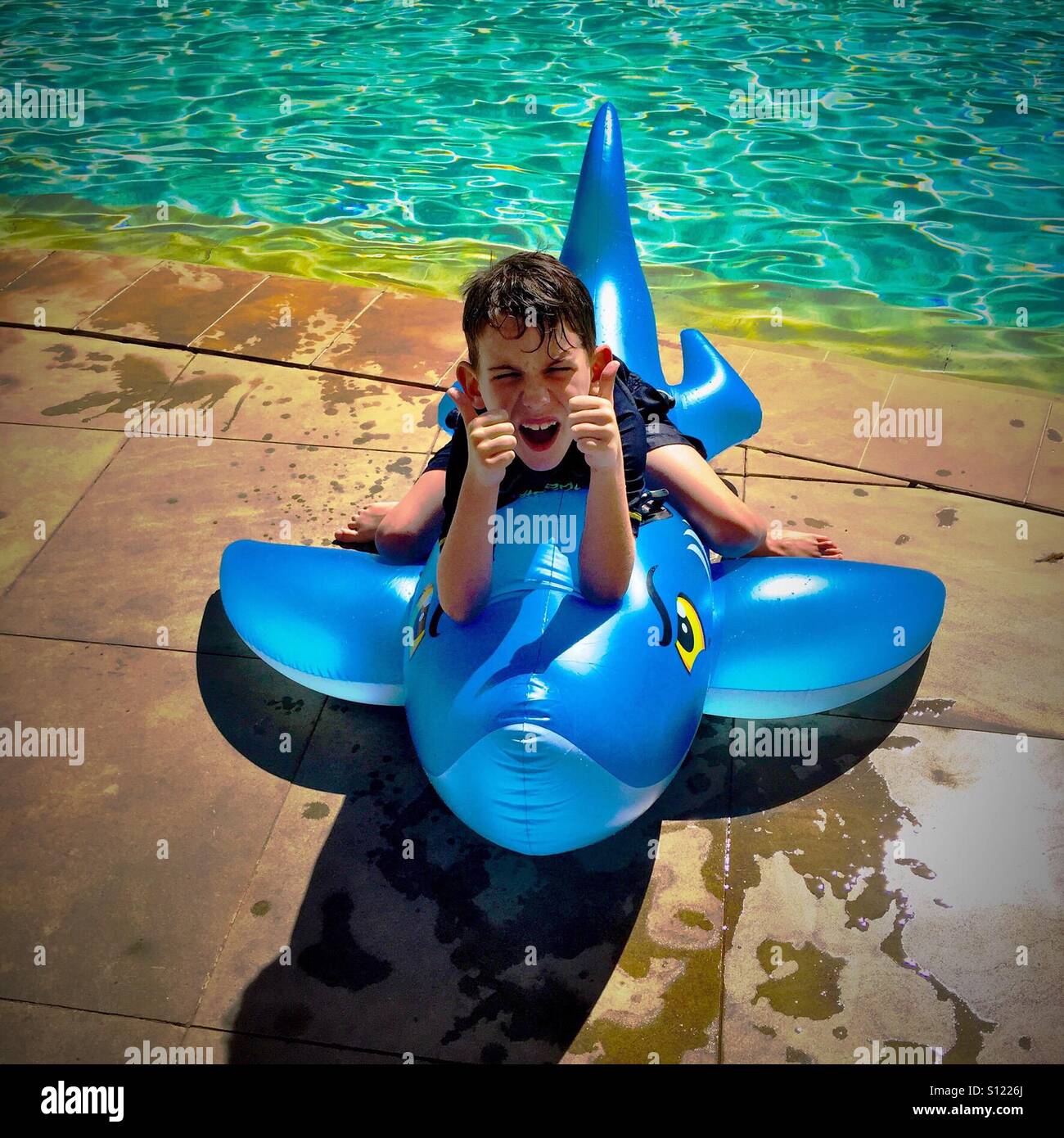 Summer Fun - boy con tiburón inflable en la piscina Fotografía de stock -  Alamy