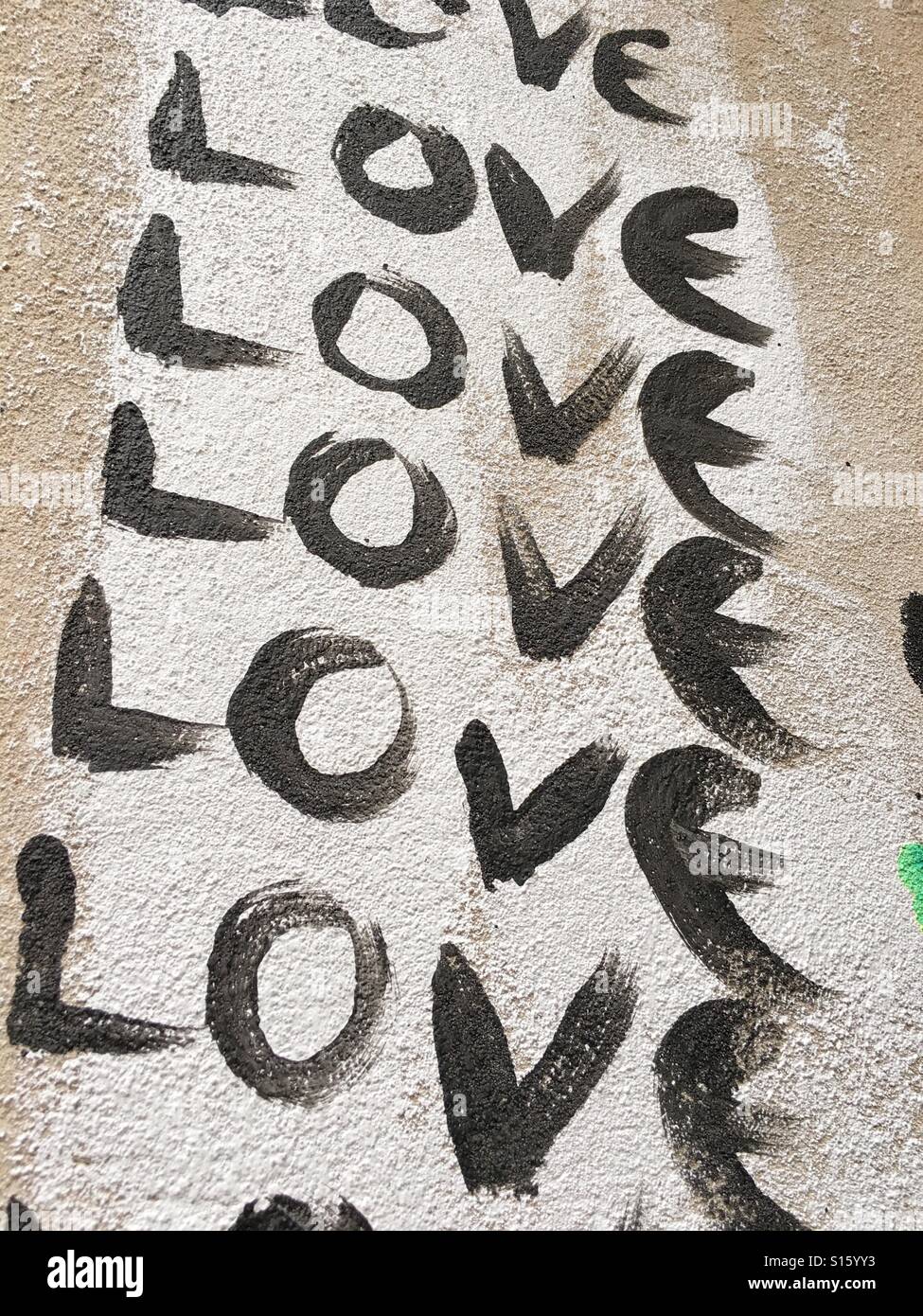 La palabra amor escrito en repetidas ocasiones sobre un muro en Berlín Foto de stock