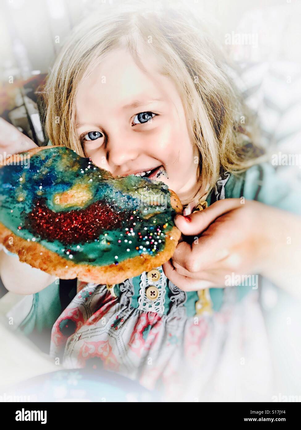 Niña mostrando su galletas navideñas que hizo Foto de stock