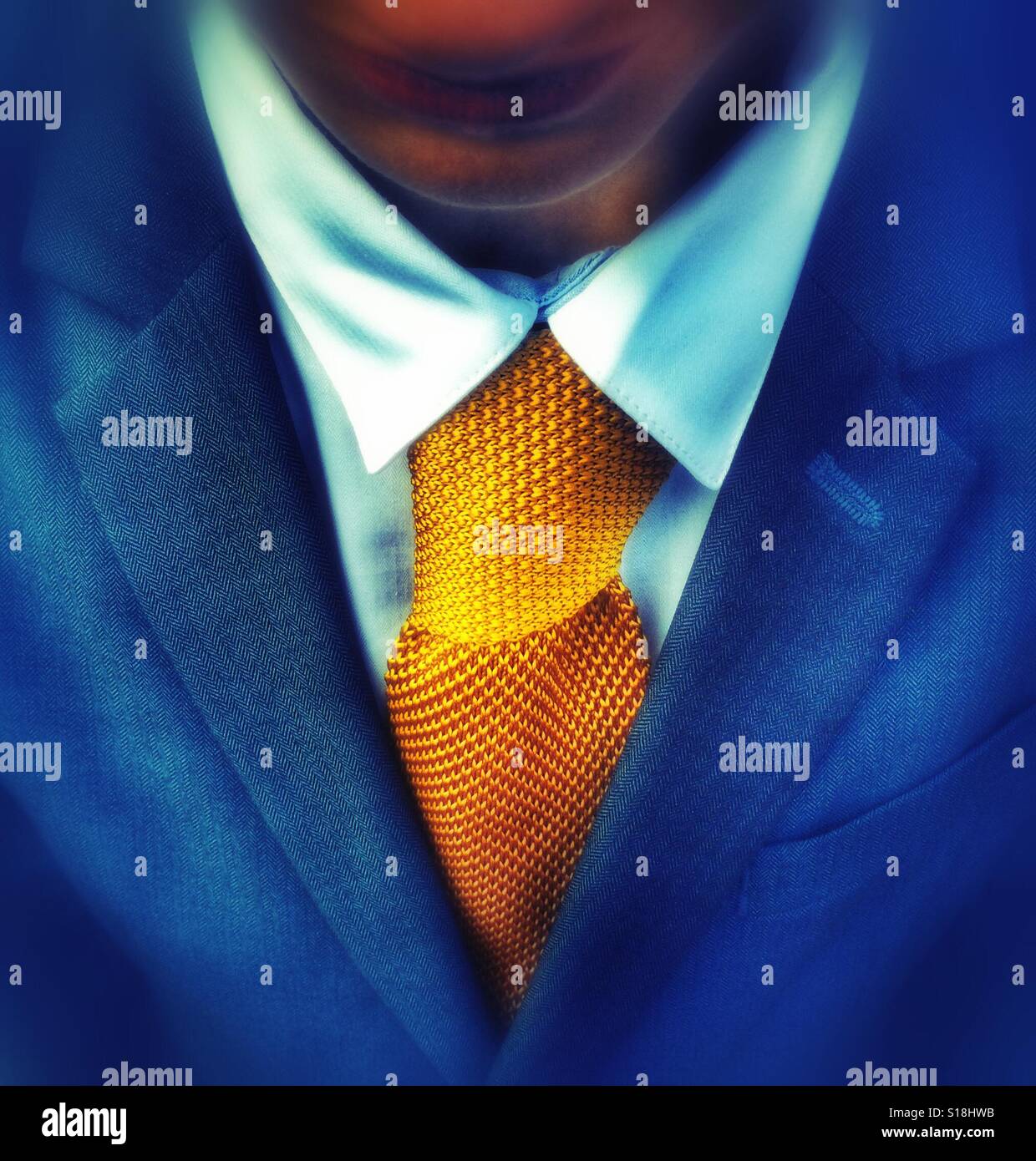 Un muchacho vistiendo un traje con una corbata amarillo brillante Foto de stock