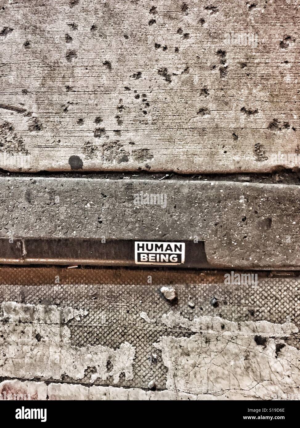 Un "ser humano" se ve la pegatina en la acera en el Lower East Side, cerca de Tompkins Square Park, momentos antes de una protesta contra la prohibición de inmigración del Triunfo. #Sticker #acera #newyorkcity Foto de stock