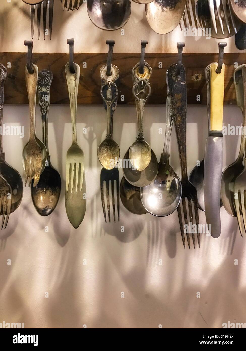 Cucharas, cuchillos y tenedores de colgar en la cocina Fotografía de stock  - Alamy