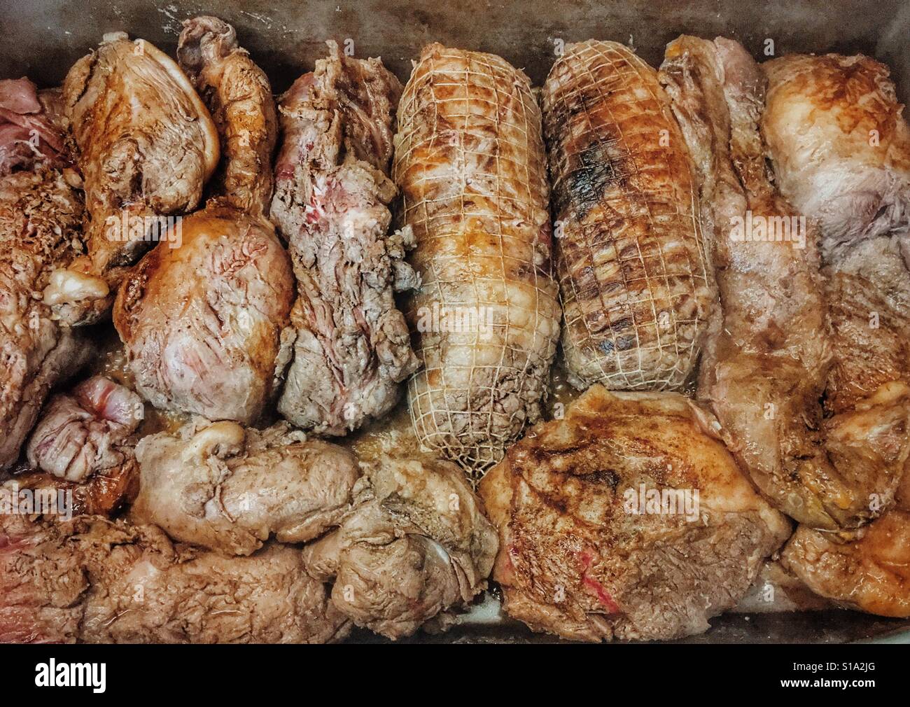 Hornear muy grandes trozos de carne de un cerdo salvaje / Carne de cerdo salvaje Foto de stock