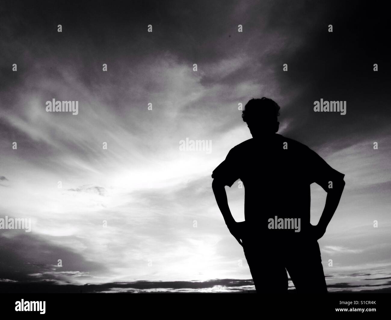 Silueta de hombre de pie y mirando al cielo - Blanco y negro Foto de stock