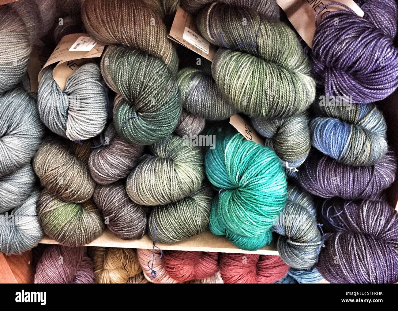 Hilos de colores o ovillos de lana para tejer en los estantes de la  mercería. tejido artesanal