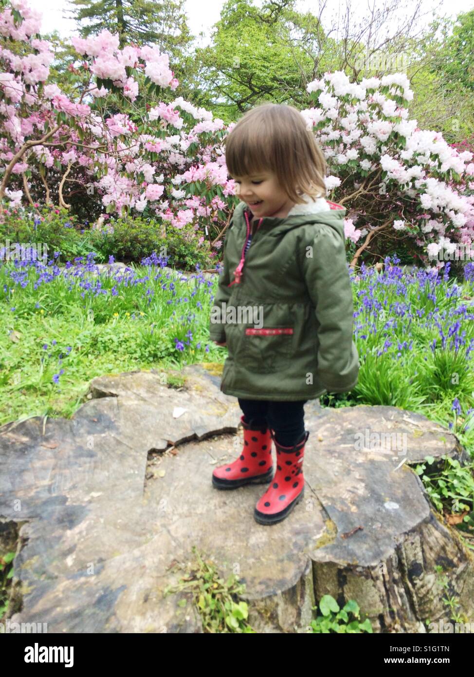 Niño Niña en botas de agua jugando en el jardín de flores Fotografía de  stock - Alamy