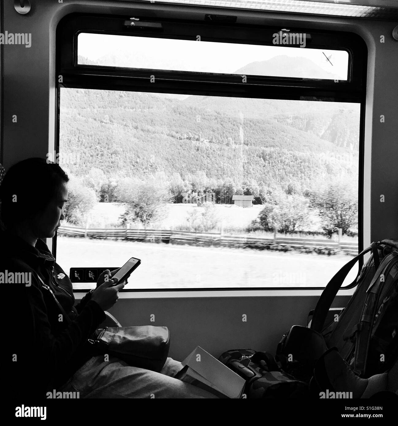 Viajeros de mochila ser pasajero de un tren, usando su teléfono Foto de stock