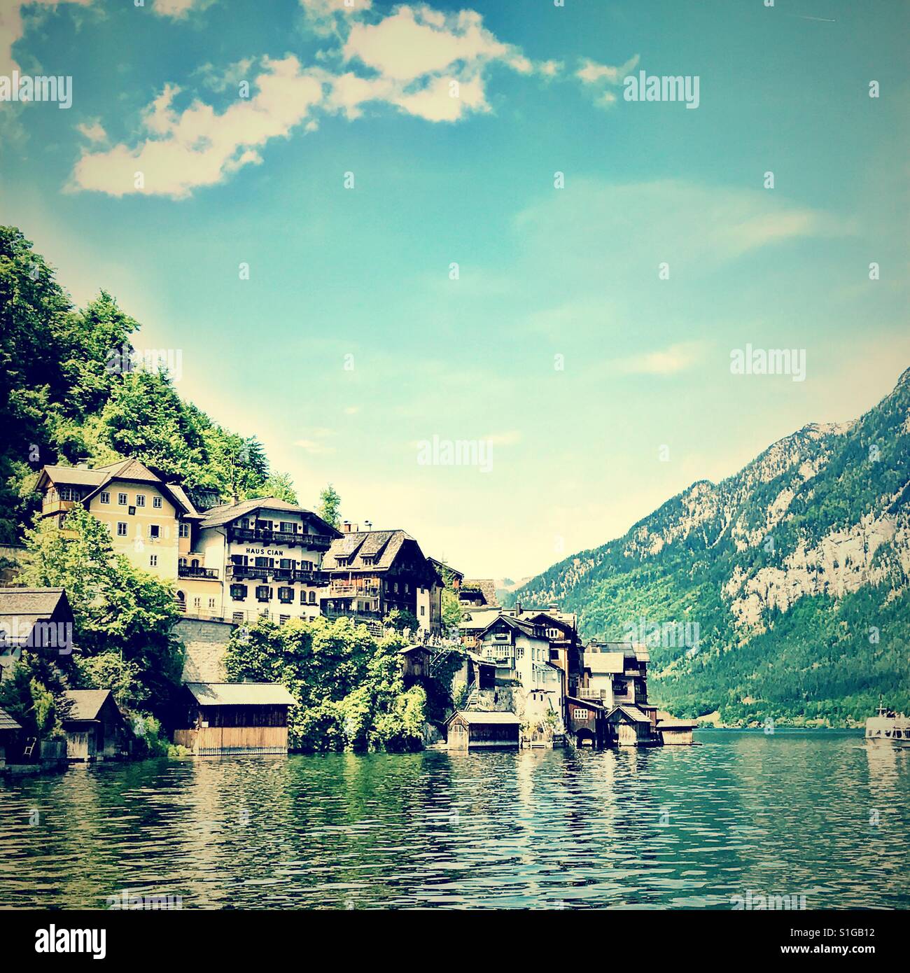 Muchas de las casas a lo largo de la ladera junto a un lago en halldstatt, Austria Foto de stock