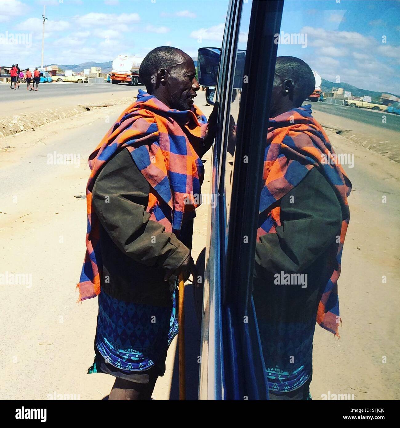 Un anciano massai a lo largo de la autopista de Nairobi, Namanga conversando con los viajeros. Foto de stock
