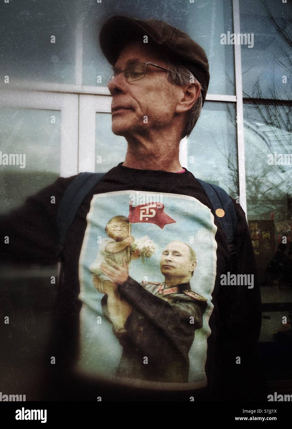 Hombres caucásicos de mediana edad con un gorro y una camiseta con la caricatura de Putin la celebración de bebé en sus manos Trump Foto de stock