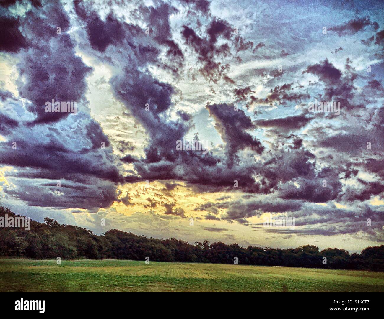 Precioso amanecer detrás de las oscuras nubes Foto de stock