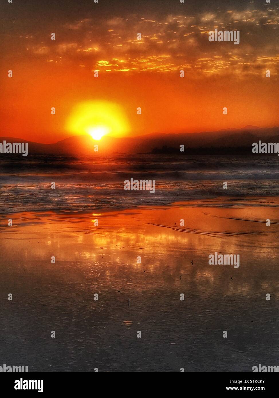 Sunset seascape en Pismo Beach, California. Vista desde la playa de océano como puesta de sol detrás de cabecera. Colores dorados Foto de stock
