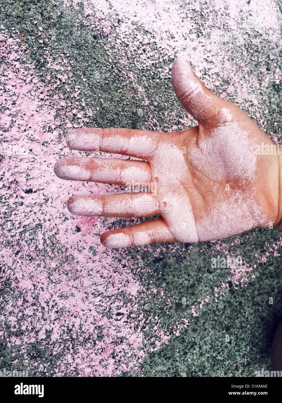 6 años de la mano de niños untados con tiza rosa Foto de stock