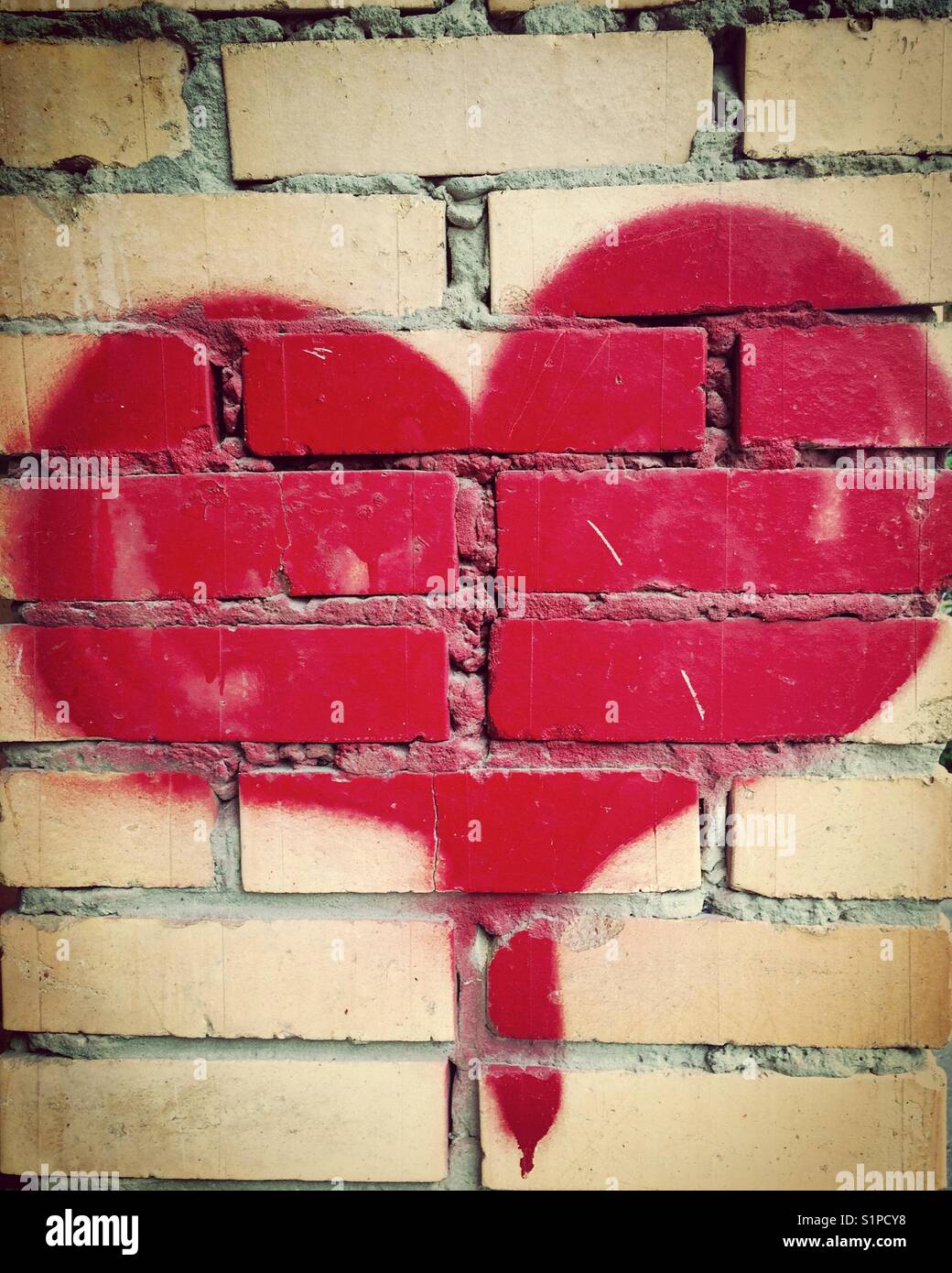 Corazón rojo dibujo en pared de ladrillo Fotografía de stock - Alamy