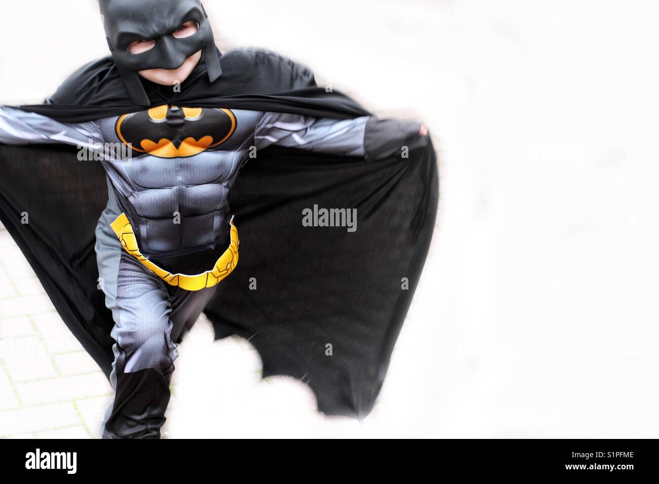 Un joven vestido como el superhéroe Batman corriendo junto con su capa  volando detrás de él Fotografía de stock - Alamy