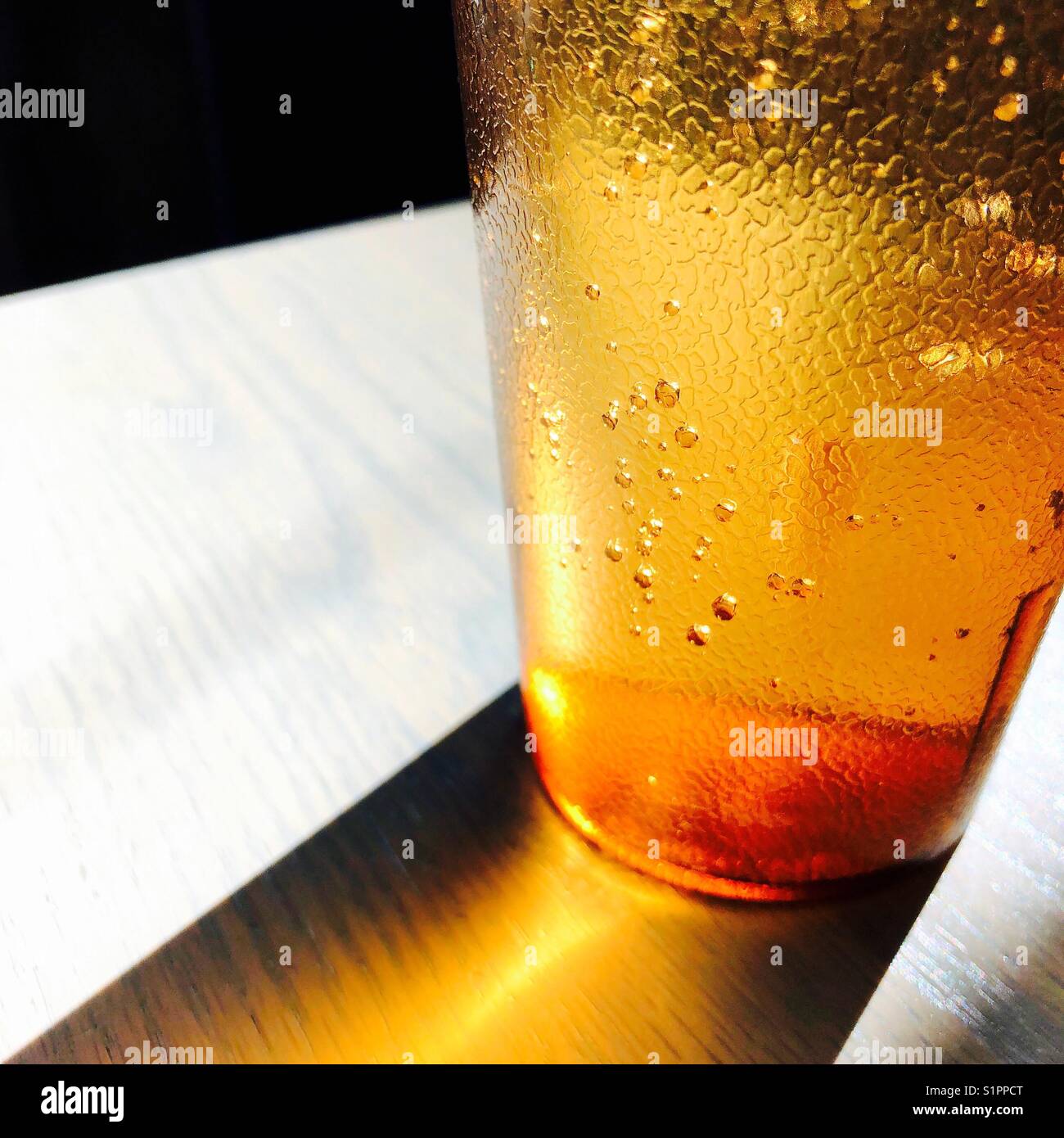 Un detalle de cerca la foto de un vaso de agua en un vaso de plástico naranja translúcido Foto de stock