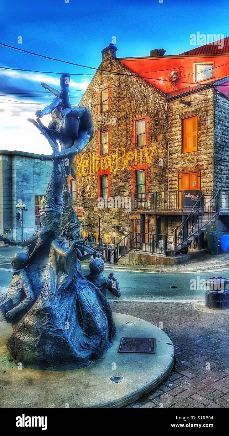 Escultura de bronce con un tiempo por Morgan MacDonald y el vientre amarillo Brewery, Saint John's, Newfoundland, Canadá Foto de stock