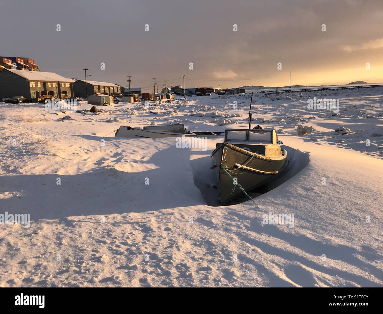 Barco enterrado en la nieve en Frobisher Bay en IQALUIT, Nunavut, Canadá Foto de stock