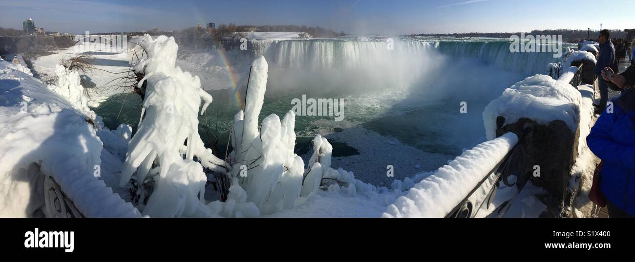 Arco iris sobre la congelación de Niagara Falls, Ontario, Canadá. Paisaje invernal de panorama de las cascadas heladas. Destino turístico favorito en todo tipo de condiciones meteorológicas. Foto de stock