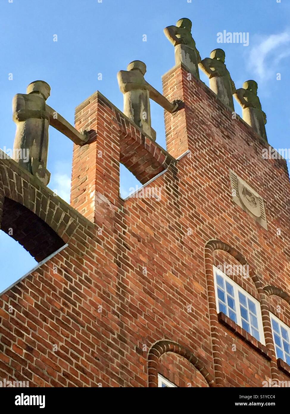Casa de ladrillos rojos gable con estatuas en la entrada Böttcherstraße, Bremen, Alemania. La Casa de los Siete Hermanos perezosos con cifras en un frontón escalonado por Aloys Röhr de Münster. Foto de stock