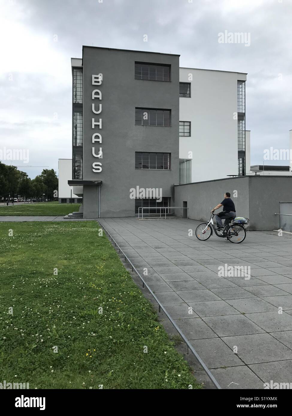 Hombre en una bicicleta en la parte delantera de la Bauhaus en Dessau  Fotografía de stock - Alamy