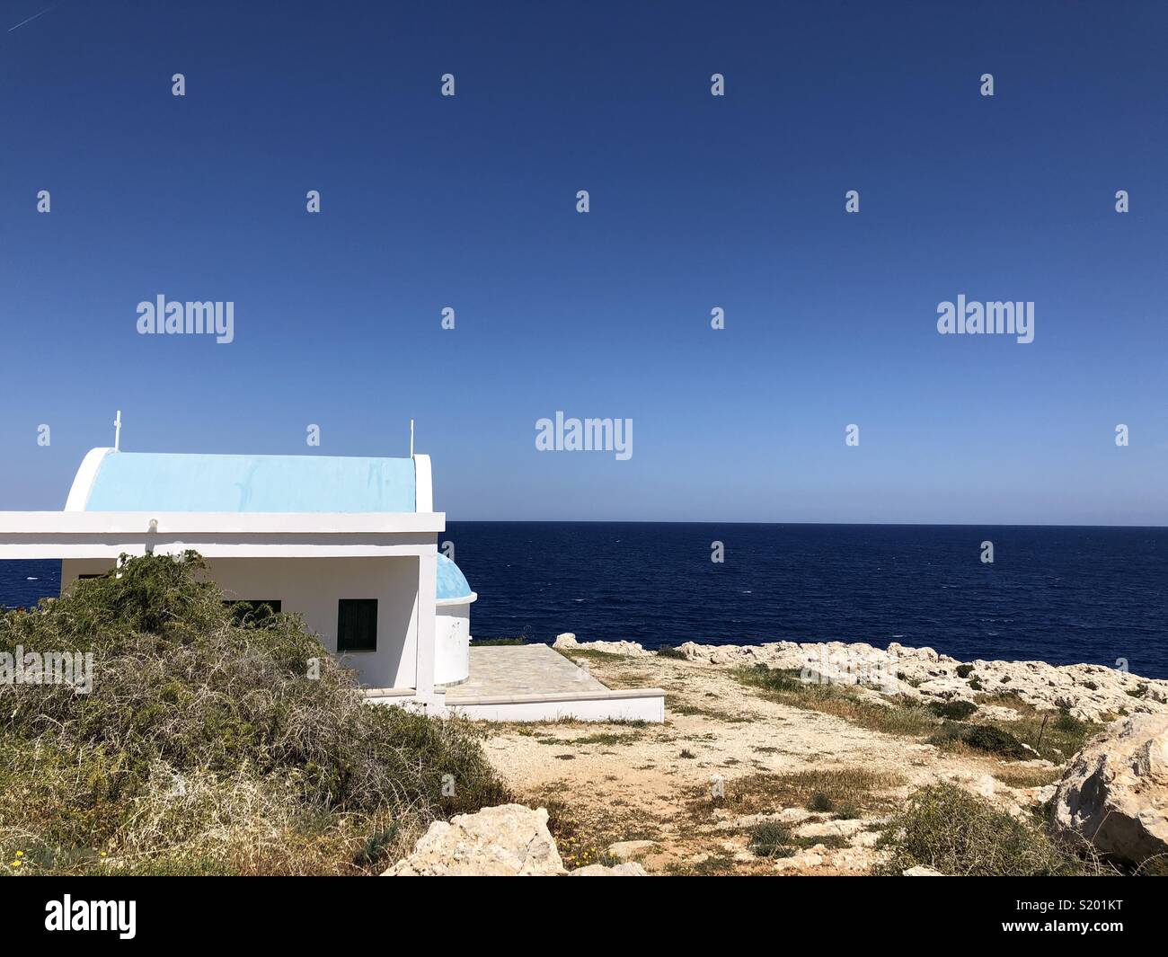 Pequeña iglesia blanca con techo azul en Capo Greko sobre Chipre Foto de stock