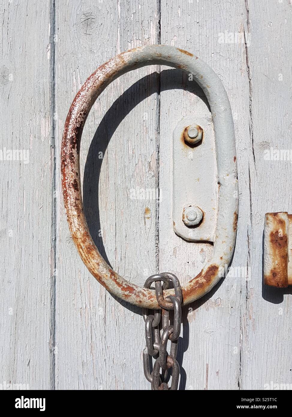 Puerta oxidada con forma de anillo y cadena letra Q Foto de stock
