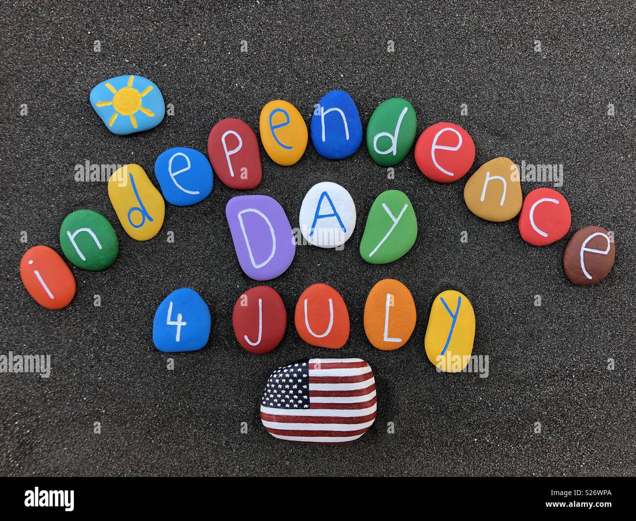 El 4 de julio, Estados Unidos de América el día de la Independencia con piedras multicolores sobre arena volcánica negra Foto de stock