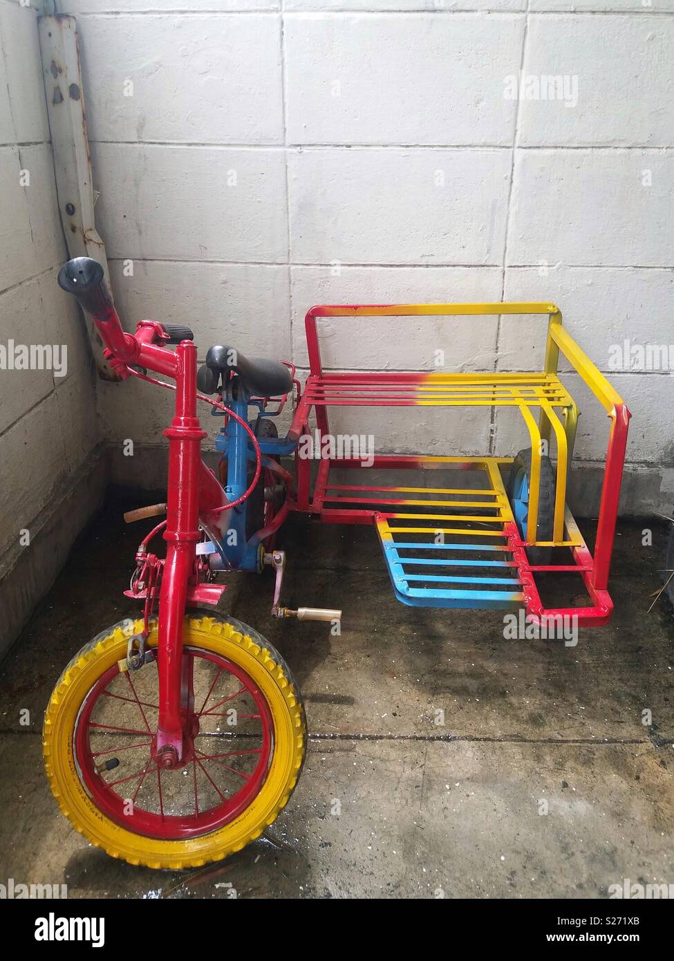 Colorido tres ruedas de bicicleta para niños creadas por hechos a mano, con  fondo de pared de cemento Fotografía de stock - Alamy