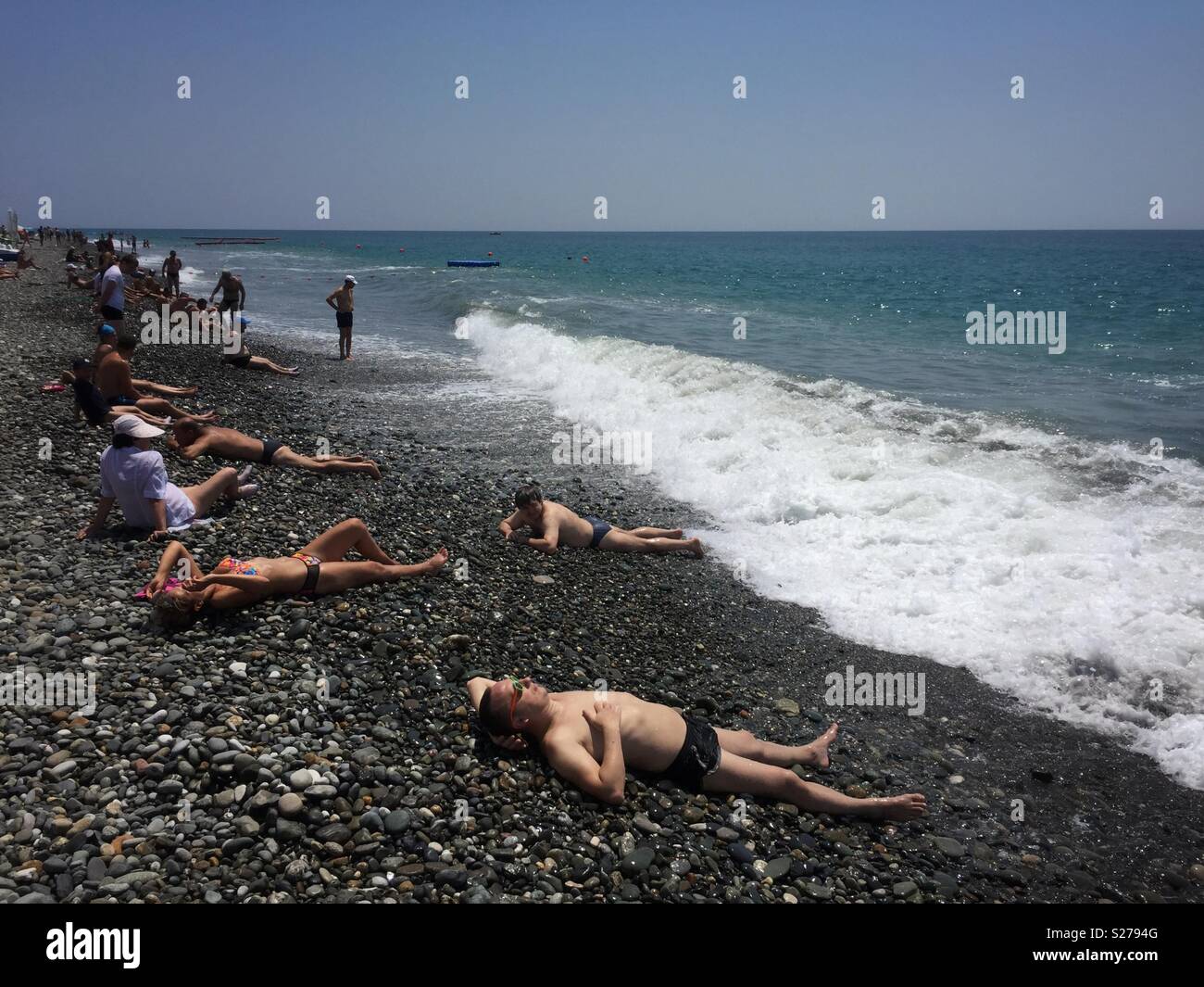 Los turistas rusos tomar el sol tumbado en las rocas junto al Mar Negro, en Sochi, Rusia. Foto de stock