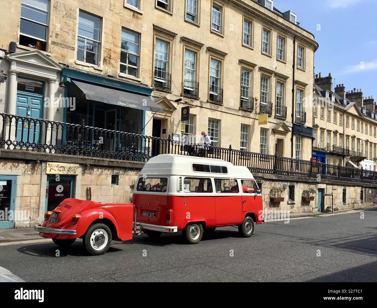 Un Volkswagen camper van remolcando un VW bug en una calle en Bath, Inglaterra Foto de stock