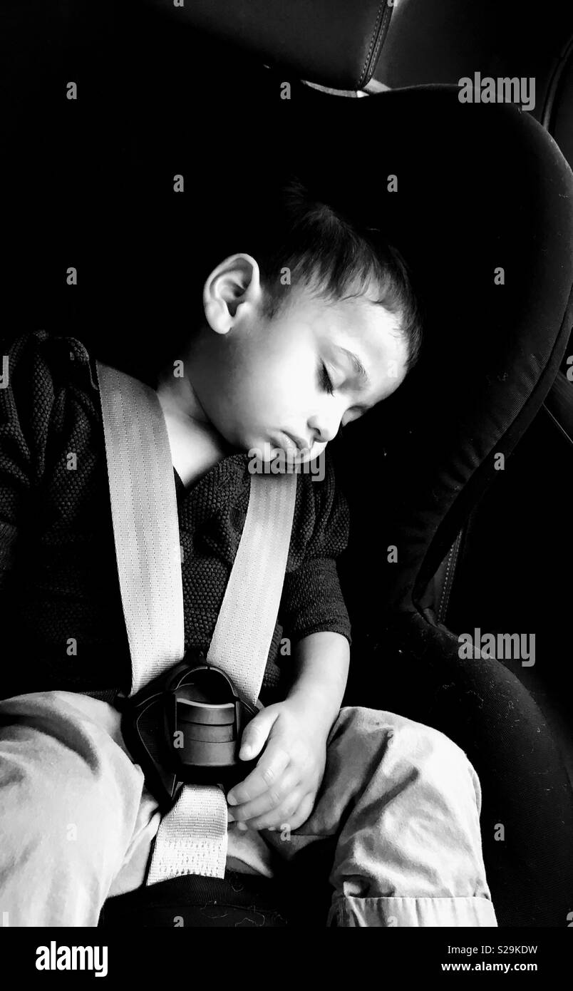 Mi hijo dormido en su asiento de coche Foto de stock