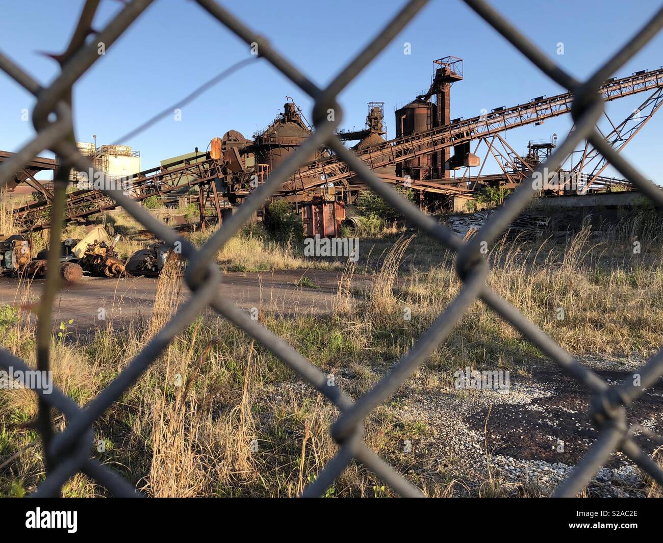 Oxidada y abandonada acería shot a través de un eslabón de la cadena cerco en Georgetown, Carolina del Sur. Foto de stock