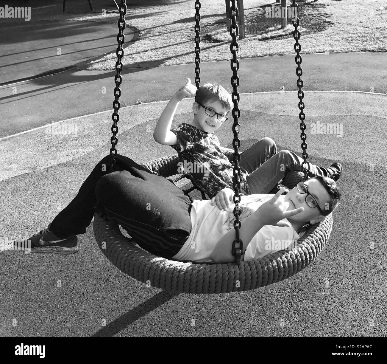 2 niños en un columpio en blanco y negro Fotografía de stock - Alamy