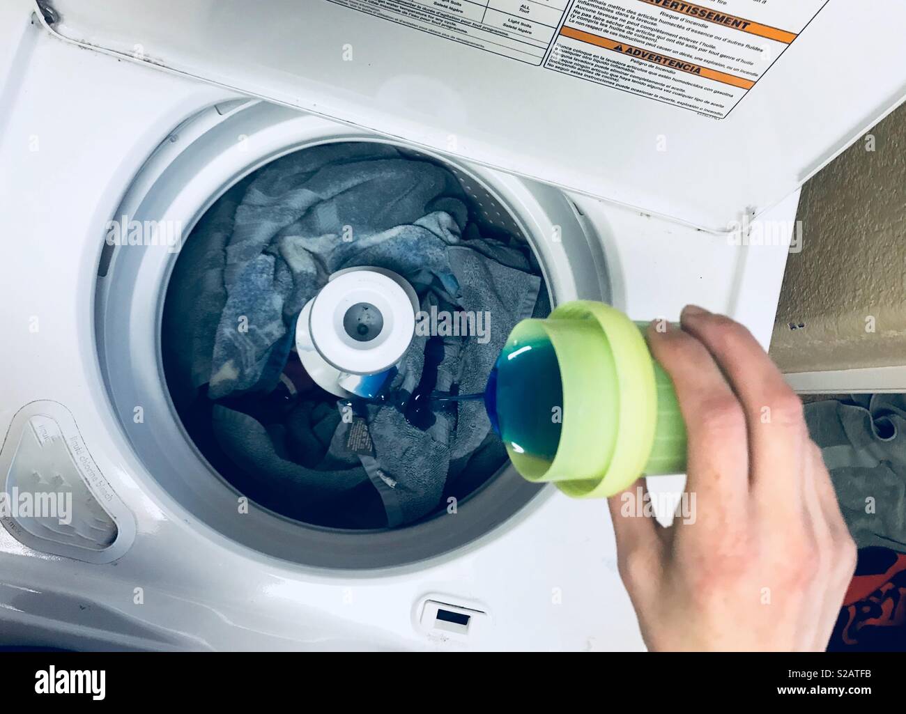 madre ropa jabón para lavar la ropa en la lavadora llena de toallas Fotografía de stock - Alamy