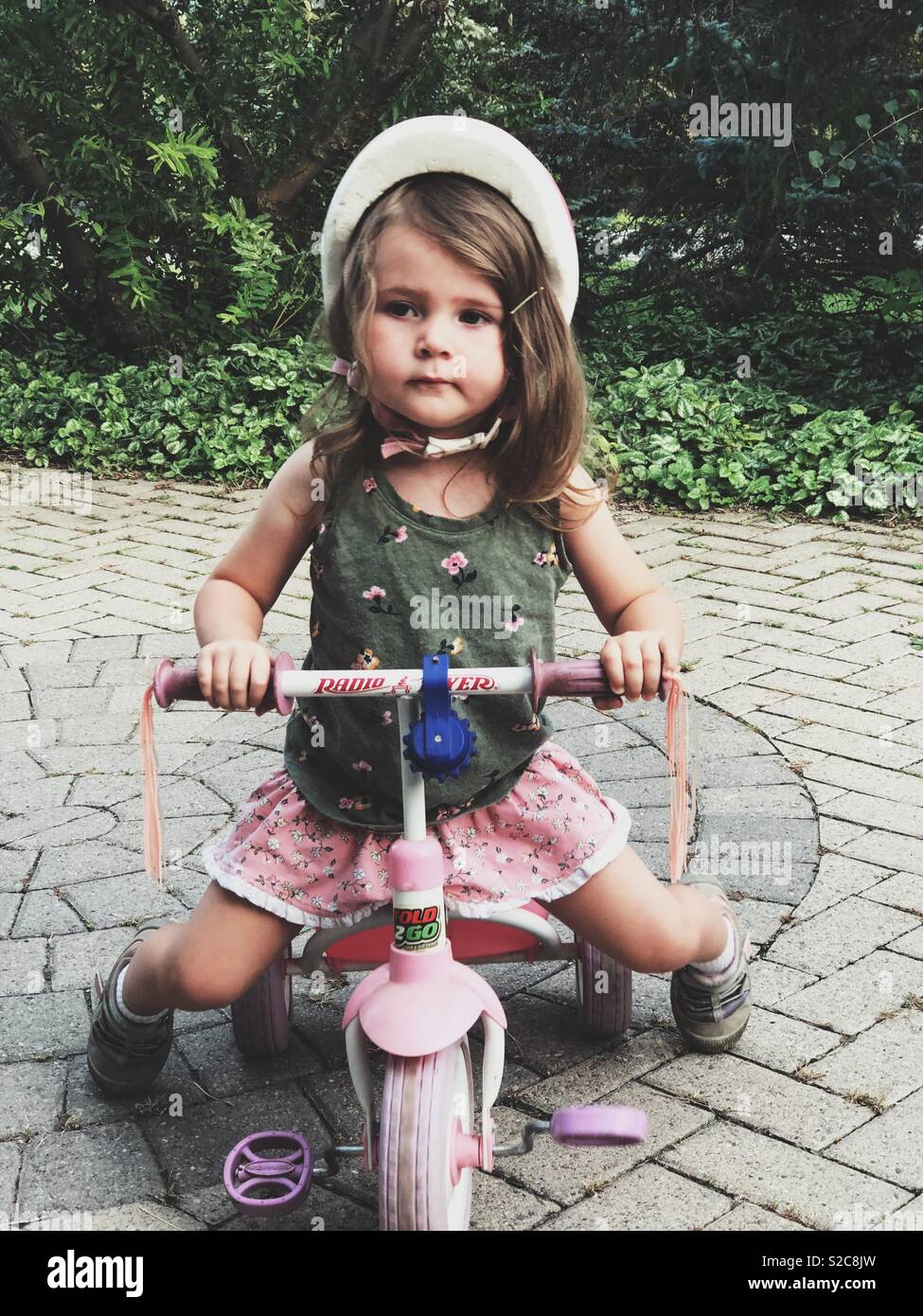 Niña de 3 años de edad llevar casco en rosa triciclo Radio Flyer Fotografía  de stock - Alamy