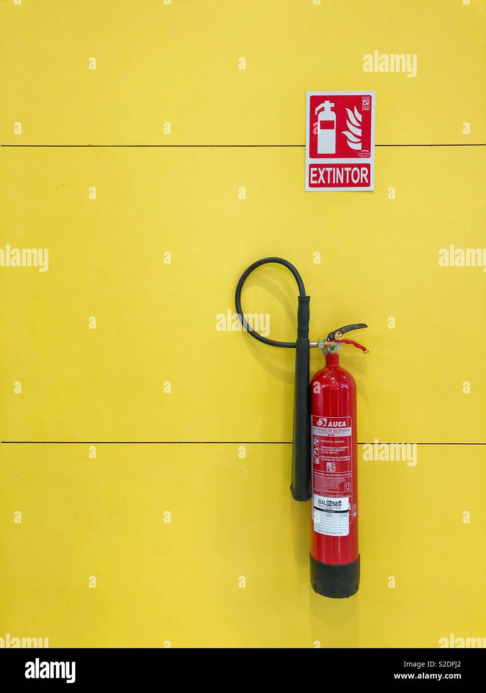Extintor de incendios en la pared amarilla en España Fotografía de stock -  Alamy